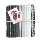 Plaid mexicain Falsa artisanal gris avec nuances de blanc et noir, modèle Ombre Discrète, présenté avec un cordage décoratif, des stickers et une carte décorative, disponible chez Las Santas.