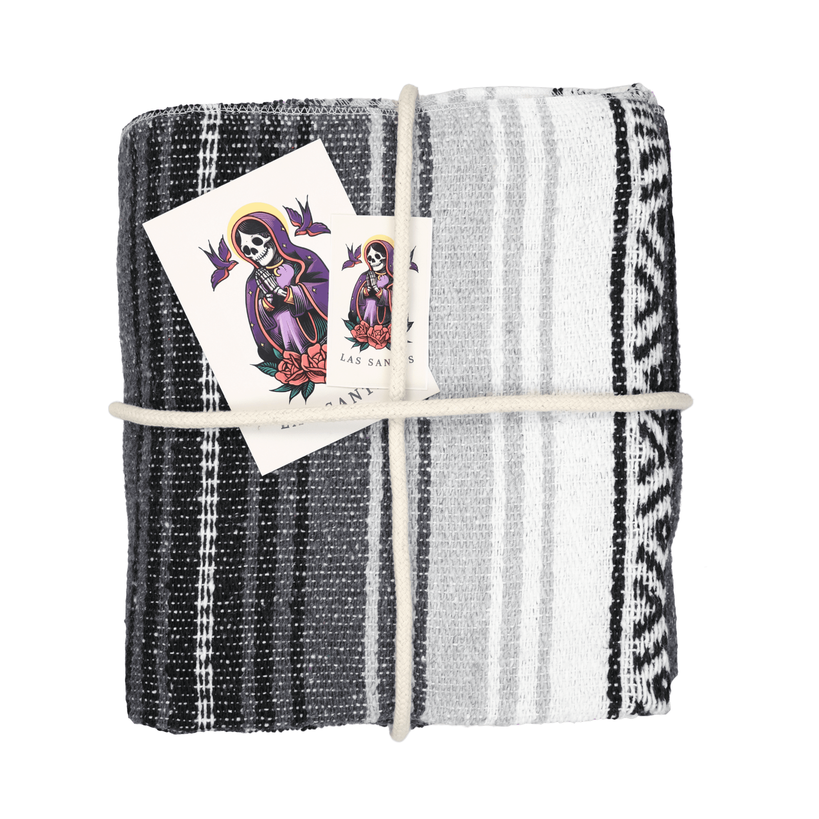 Plaid mexicain Falsa artisanal gris avec nuances de blanc et noir, modèle Ombre Discrète, présenté avec un cordage décoratif, des stickers et une carte décorative, disponible chez Las Santas.